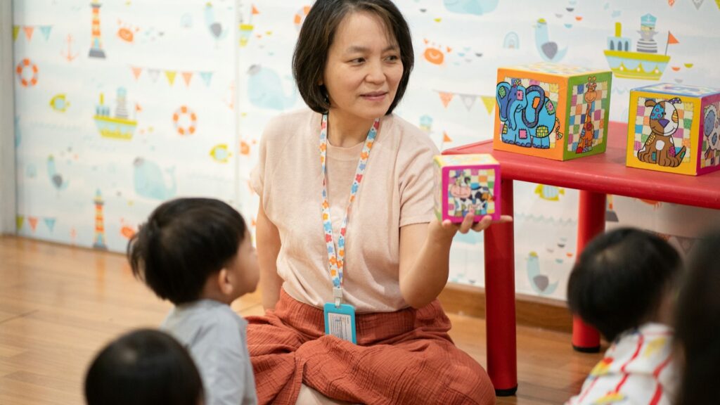 Pedagogisch medewerker begeleidt peuters tijdens een educatief spel met blokken